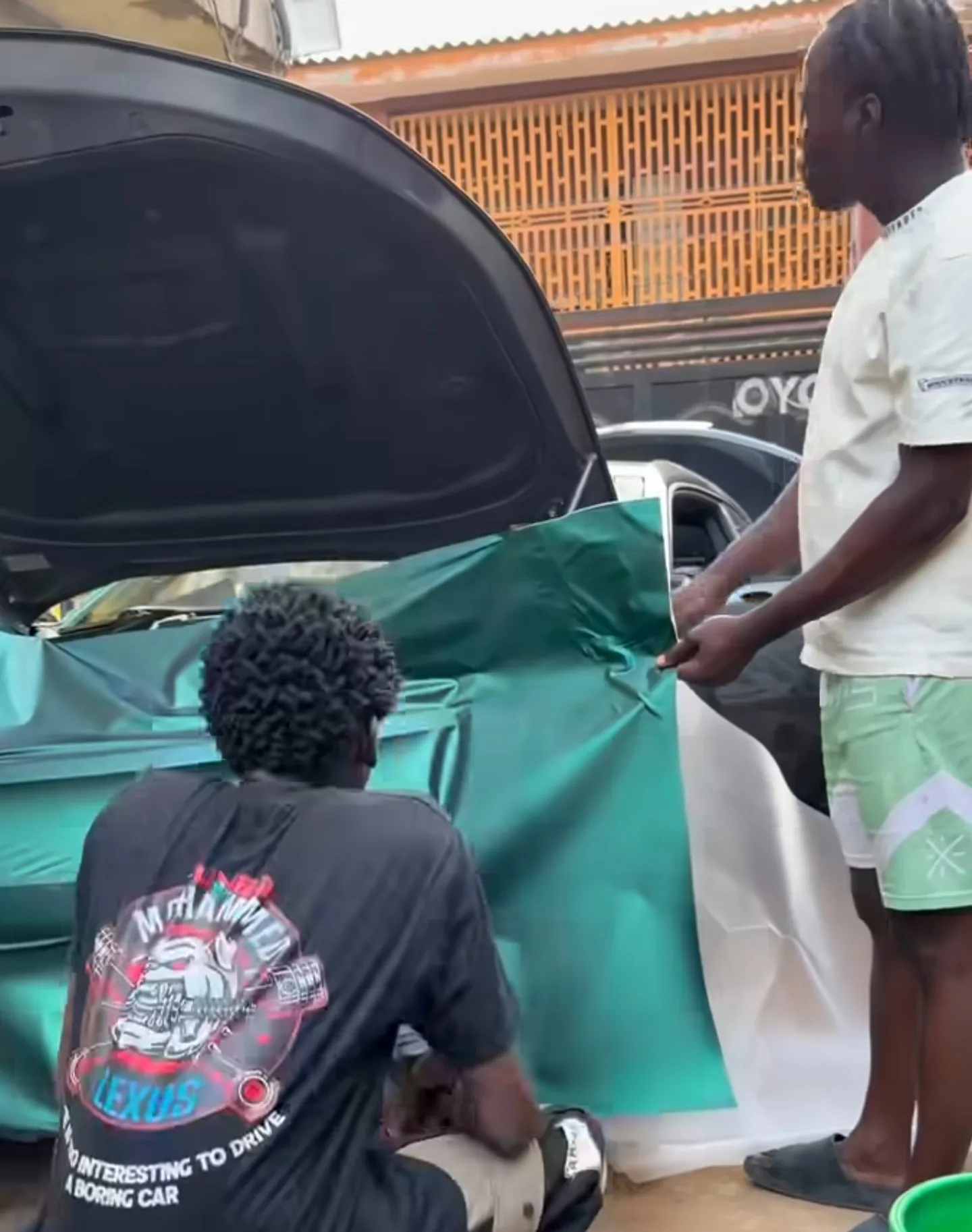 Mohammed Lexus team at Camaro open boot trunk applying matte green vinyl rear section