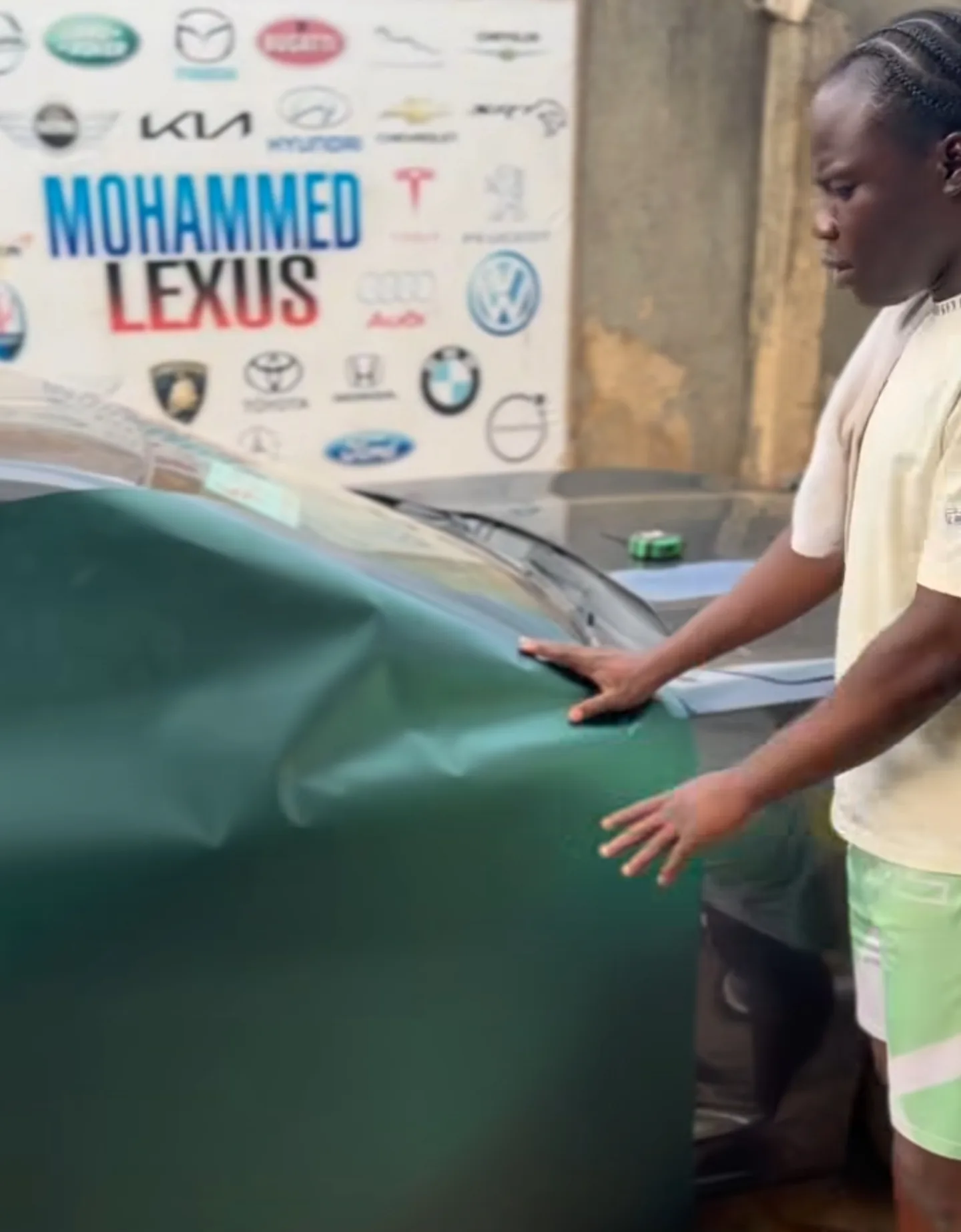 Mohammed Lexus team applying matte dark green vinyl to Camaro roof panel process Lagos