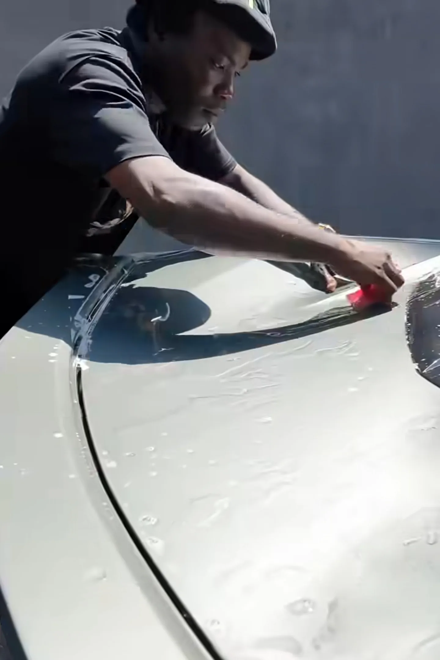 PPF transparent film being applied to Corvette C8 bonnet with squeegee Mohammed Lexus