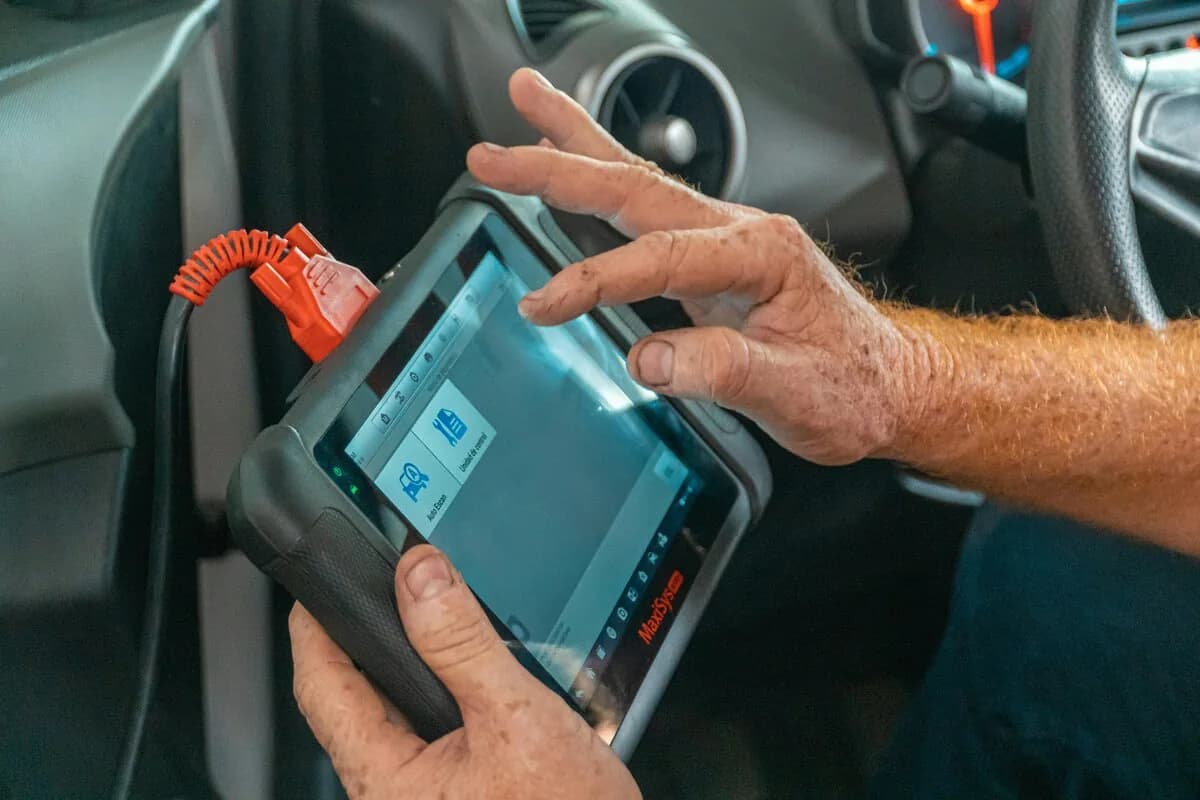 OBD2 scan tool diagnostic device held by mechanic for car ECU diagnosis