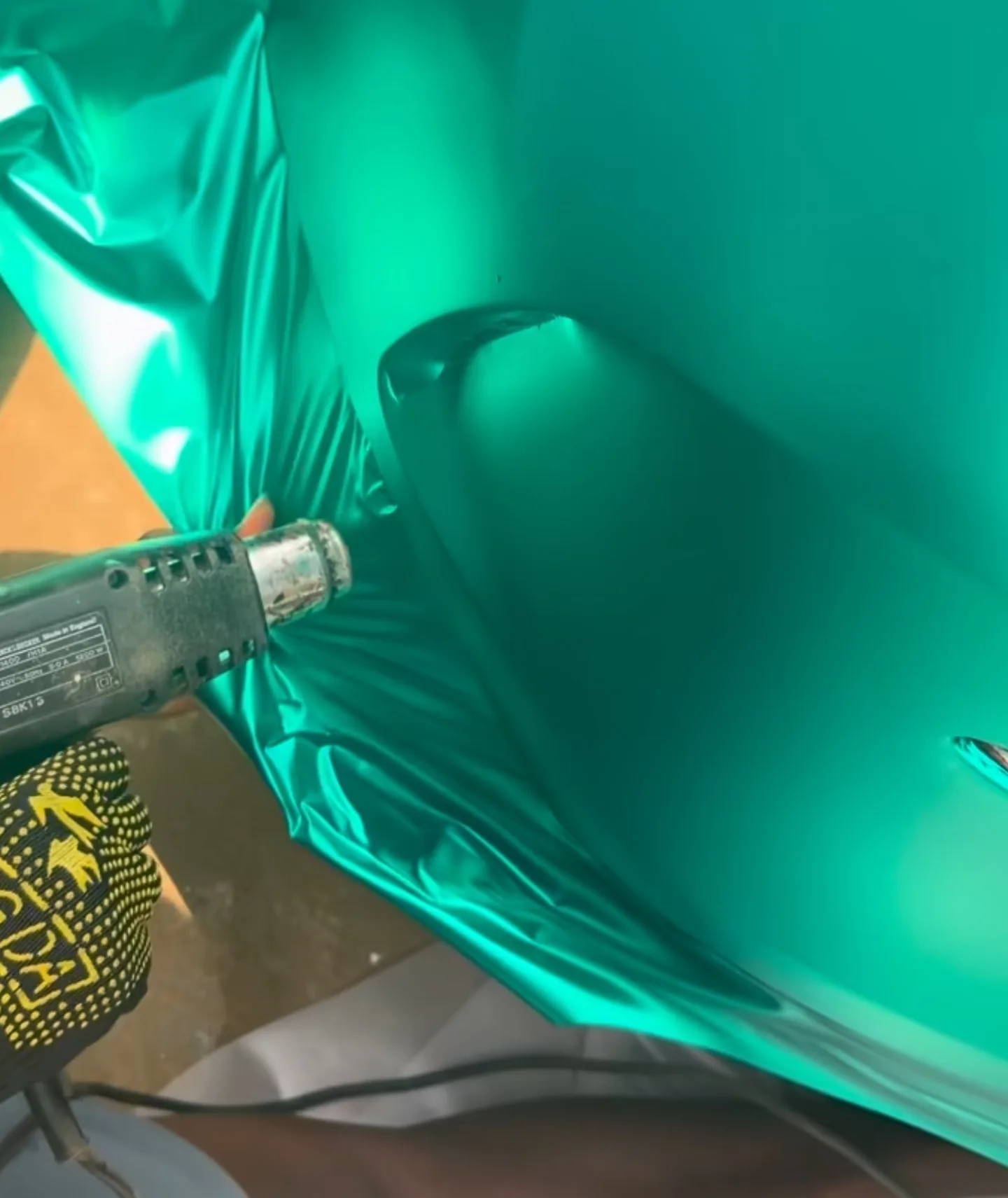Satin aqua green vinyl heat gun forming around Mercedes C43 AMG curved panel process Lagos