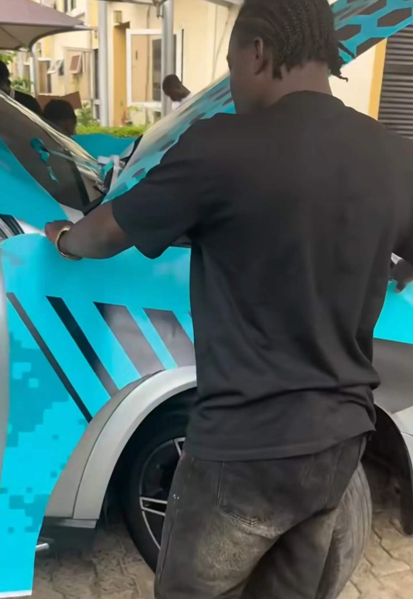 Mohammed Lexus technician applying custom teal honeycomb wrap to GLE door panel precise alignment