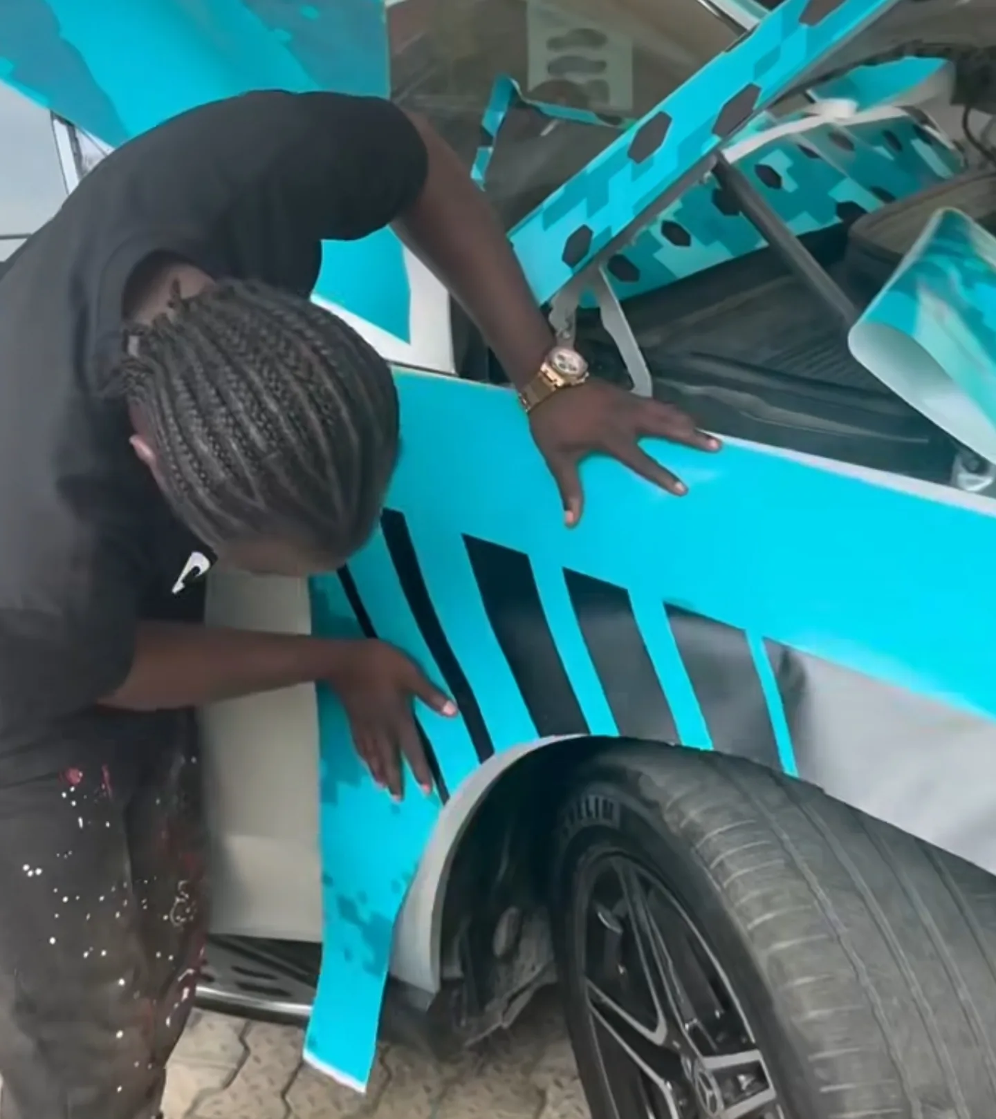 Peller inspecting completed custom teal geometric honeycomb wrap on Mercedes GLE door panel Lagos