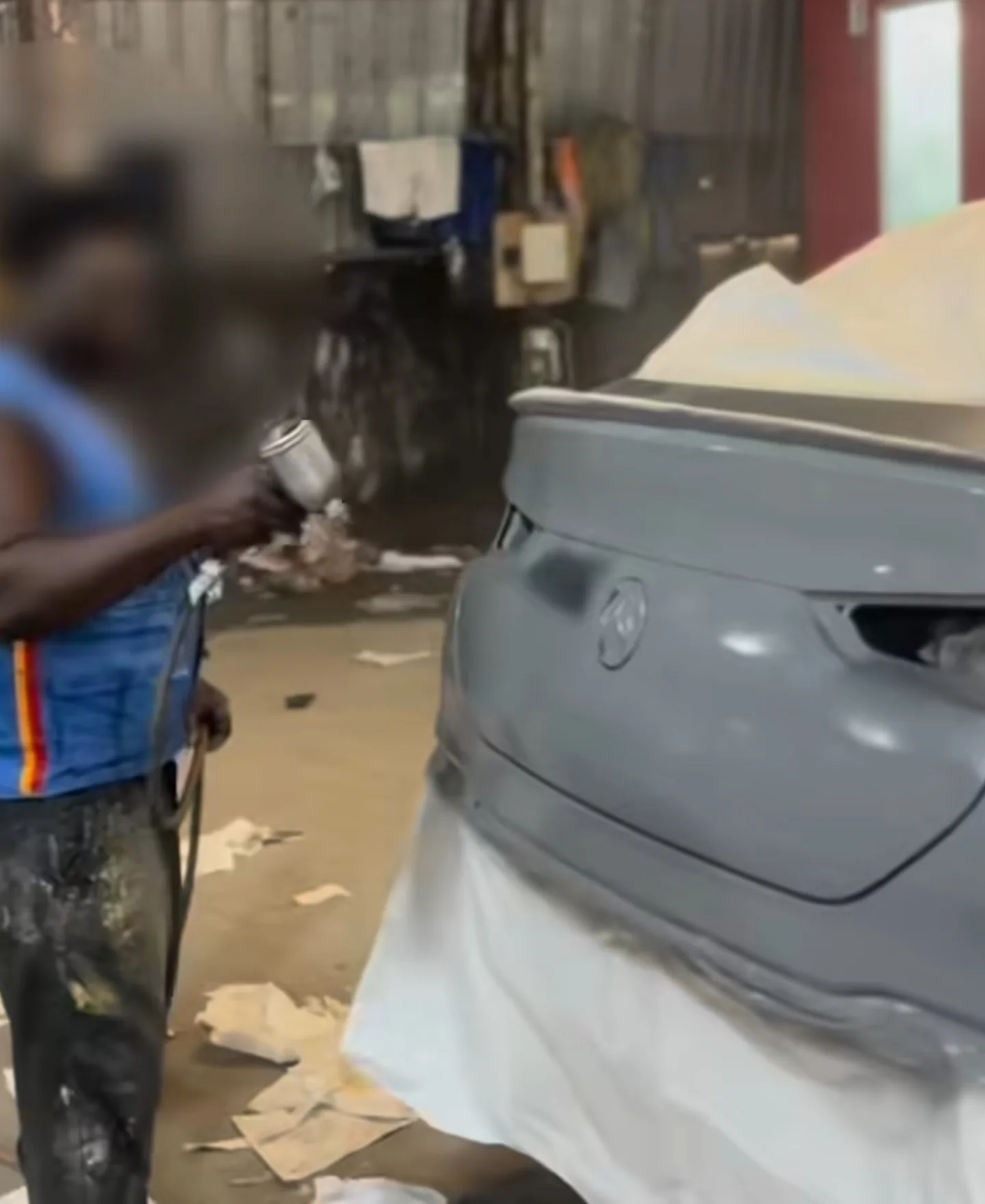 Technician spray-painting Mercedes GLE 53 rear bumper grey in Mohammed Lexus workshop