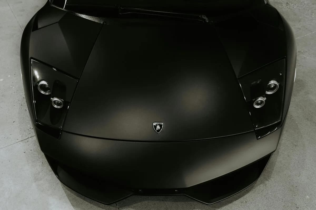 Sleek matte black wrapped car top view overhead shot dramatic colour change result